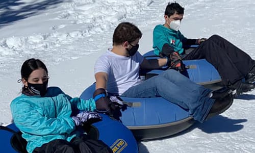 Kids in the snow on innertubes