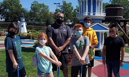 Group of Kids and adults playing mini golf