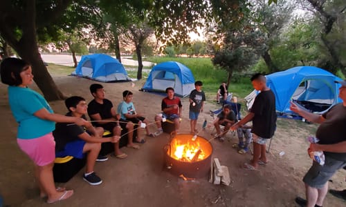 Kids toasting smores around a firepit