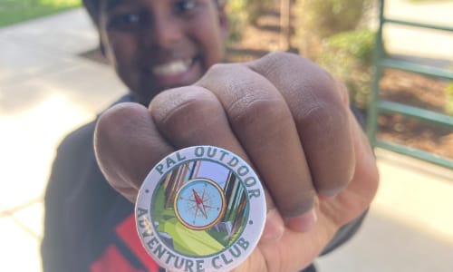 Boy holding adventure club pin