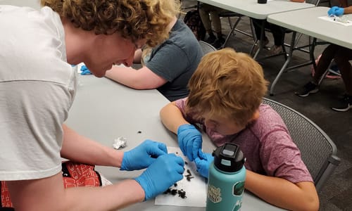 Kids doing some Earth Science. Unknown what they are doing beyond that in the image